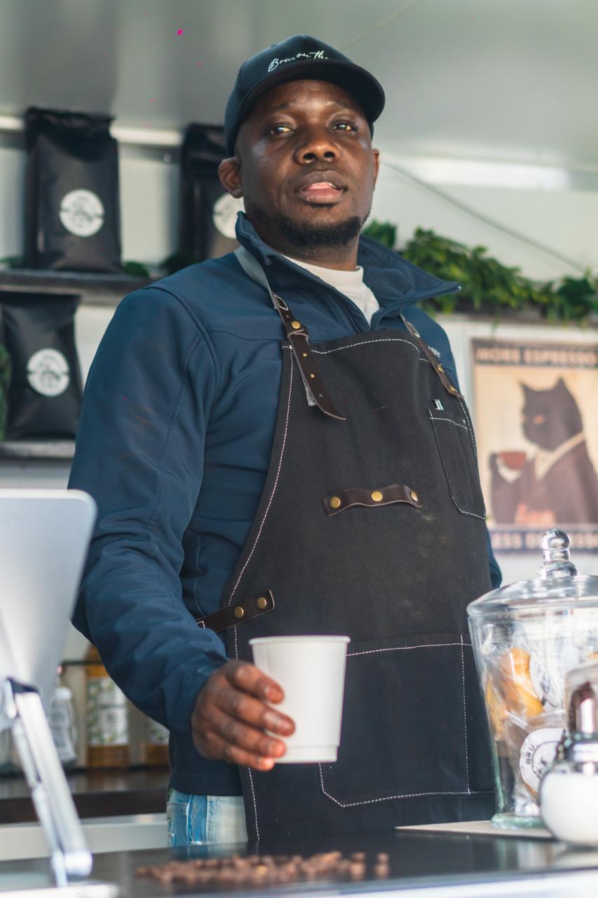 BRU. barista in apron behind the counter